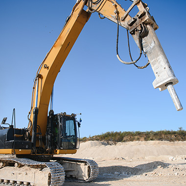 excavator with hydraulic breaker in operation on construction site three construction tools being used for demolition