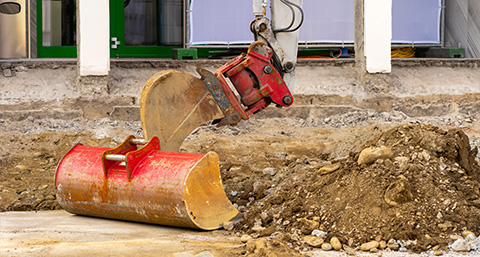 heavy construction machinery with red excavation bucket digging into dirt on a construction site 2 types of equipment 2 earthmoving 2 site preparation