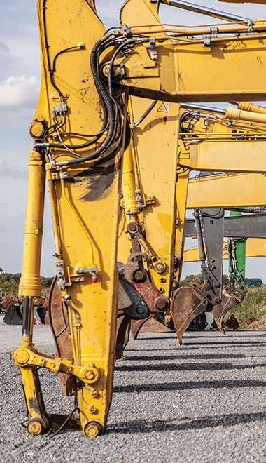 yellow excavator arms lined up construction site machinery industrial strength